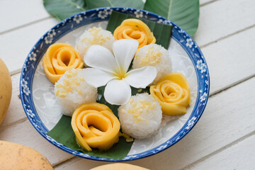Thai dessert,mango and sticky rice with coconut milk On a white wooden table ,Floral Pattern Cup,Popular menu of Thai people.