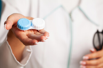 Female doctor close up holding a container with optical lenses