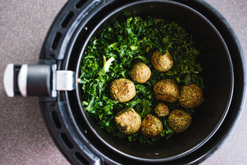 plant-based food, falafels and kale chips in air fryer