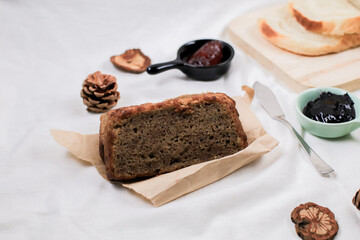 Close up Homemade delicious freshly baked classic sweet banana bread sliced with blueberry/strawberry jam and butter knife on a white yellow tulip background.Ideas picnic recipe healthy diet breakfast