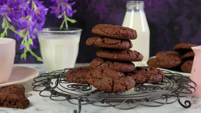 Stack of double chocolate chip homemade cookies in creative vintage setting against a purple and white marble background. Dolly shot.