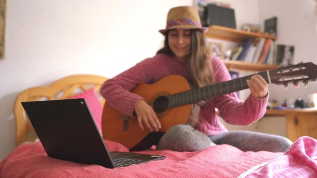 music online class, guitar clases online, female playing guitar on bed