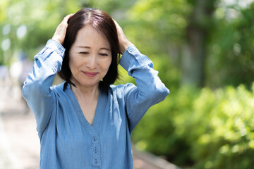 頭痛に悩むシニア　アジア人　女性