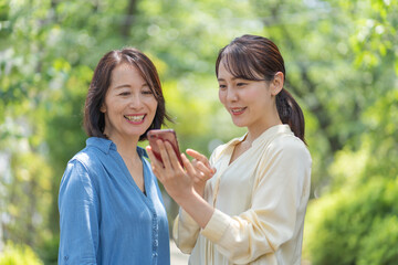 携帯を見るアジア人親子のポートレート