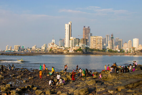 Mumbai India Nov 9th 2019: the people have fun on beach in front of Pir Haji Ali Shah Bukhari, a mosque and dargah (tomb) or the monument. The background is Haji Ali Bay and part of skyline of Mumbai.