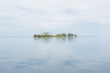 Paradise white sand island with palm tree huts isolated in the caribbean sea in Guna Yala San Blas Panama, Vertical Wide Shot