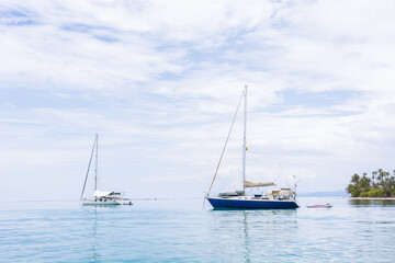 Obraz premium Beautiful seascape of blue sea with floating yacht and white cloud sky. luxury summer day lifestyle vacation tourism travel in Guna Yala, San Blas Islands, Panama, Central America - Horizontal wide