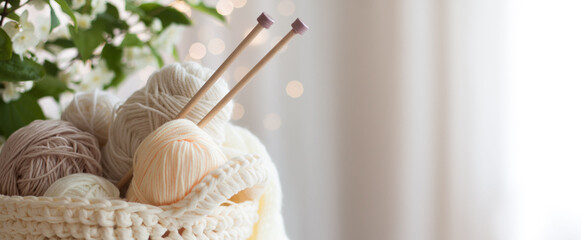 Knitted white and beige fabric. Woolen and cotton yarn lies in a basket. Glasses lie on a white...