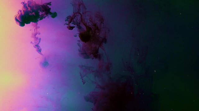 Drops of dark ink on colorful background dissolve beautifully in water. Stock footage. Drop of blood under water create beautiful smoky form