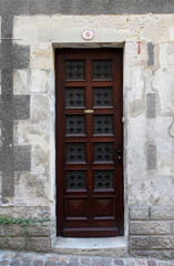 Fototapeta na wymiar Brown door in facade of residential building surrounded by bricks