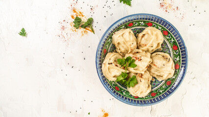 Uzbek prepared boiled Manti or manty dumplings in a traditional bowl on wooden table. banner menu...