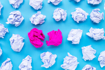 White with pink crumpled paper balls on a blue background.