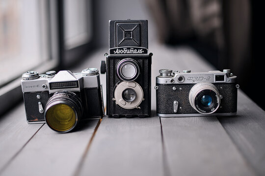 Three Old Reflex Cameras Isolated On Wooden Background vintage twin Lens reflex camera