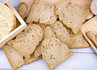 Fresh whole wheat bread, cut into slices Stacked on a wooden table.