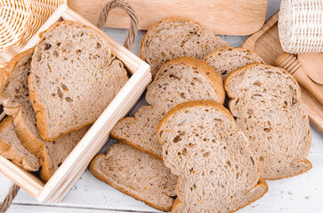 Fresh whole wheat bread, cut into slices Stacked on a wooden table.