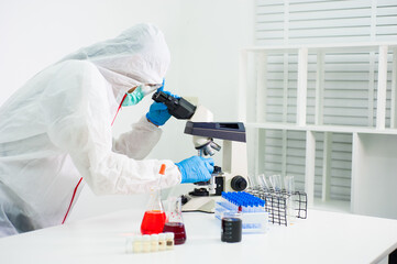 Scientists do research and look through the microscope in the laboratory.