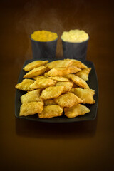 Porção de mini pasteis fritos com molhos