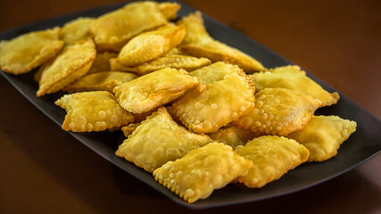 Porção de mini pasteis fritos com molhos