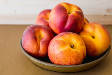 Naklejka na ściany i meble Peaches close up. Fresh ripe organic peaches on a plate
