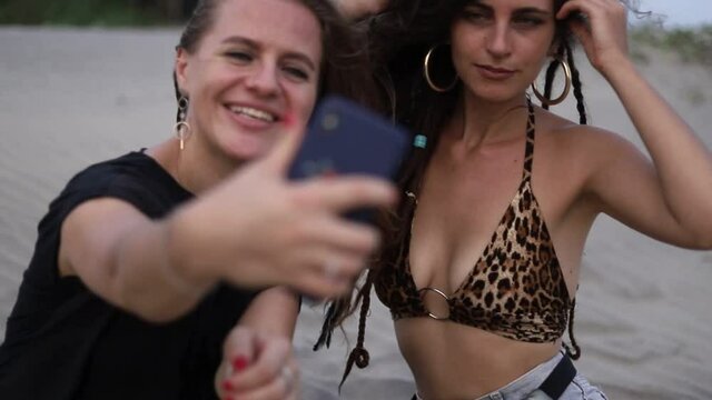 2 girls taking selfi on the beach