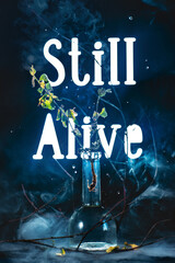 Still alive backlight text with crooked branches and dried leaves, death and rebirth concept