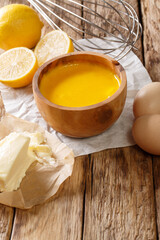 Traditional hollandaise sauce with ingredients eggs, lemon, butter close-up on the table. vertical