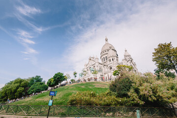 Basilica of the Sacred Heart of Paris Sacré-Cœur on the hilltop with grass and beautiful sky