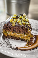 Fatia de bolo de chocolate com recheio de doce de leite e cobertura de nozes