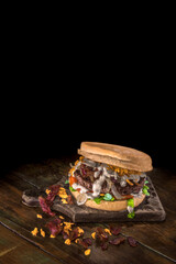  Hambúrguer de carne com cream cheese cebola crispy sobre mesa de madeira