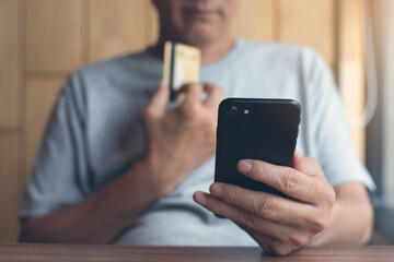 Asian man online shopping making internet payment via mobile phone banking app