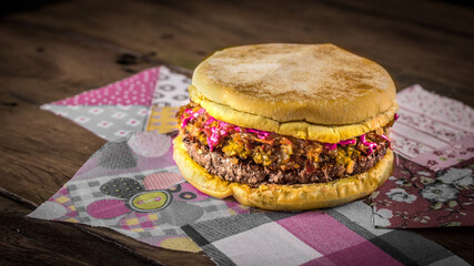 Hambúrguer de carne com cheddar molho de beterraba sobre mesa rústica sobre mesa de madeira