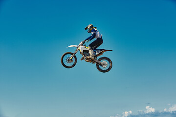 Motocross concept, a biker goes off-road making extreme skiing. In pursuit of adrinalin, sport concept. Dangerous sport.