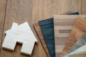Fototapeta na wymiar top view on tiny house model with stack of vinyl sheet sample tile for floor material selection design