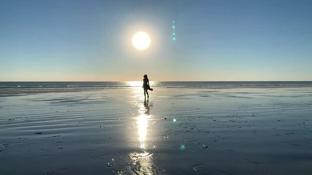 Woman walks on the beach at sunset - Broome - Western Australia