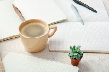 Cup of coffee with notebooks on white background