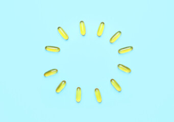 Frame made of fish oil capsules on color background
