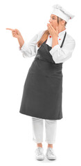 Shocked female chef pointing at something on white background