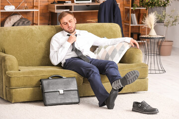 Businessman taking off his shoes at home after long working day