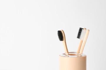 Holder with toothbrushes on light background