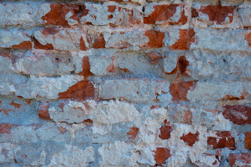 the wall of the house made of reddish brick and painted with white paint