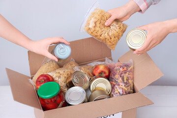 Volunteers putting products in donation box on table