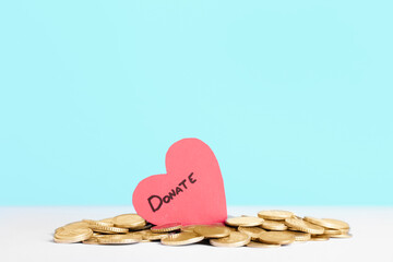 Red heart and coins on table. Concept of donations