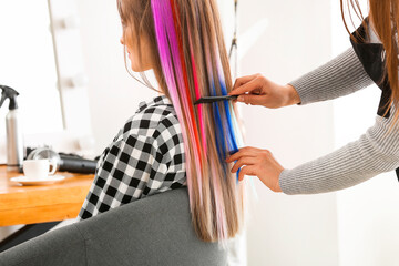 Hairdresser working with young woman in beauty salon