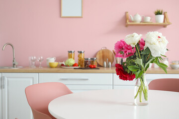 Bouquet of flowers on table in kitchen