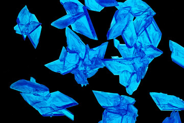Beautiful crystals of Copper Sulphate shown in close-up and isolated against a black background. Copper Sulfate is used in industry, agriculture and medicine and is commonly used in school science. 