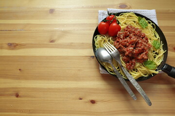 tomato and Basil pasta cooking in a pan gourmet, homemade dish on a wooden table