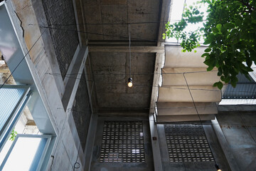 Obraz premium Interior ceiling design and loft architecture of old building structure decorated with cement concrete wall, industrial furniture and hanging lamp