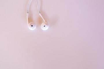White headphones on pink background.