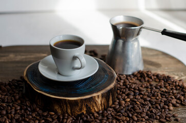 a cup of coffee with sprinkled coffee beans on the table