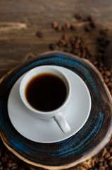 a cup of coffee with sprinkled coffee beans on the table